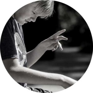 circle cropped black and white image of boy gesturing with hands