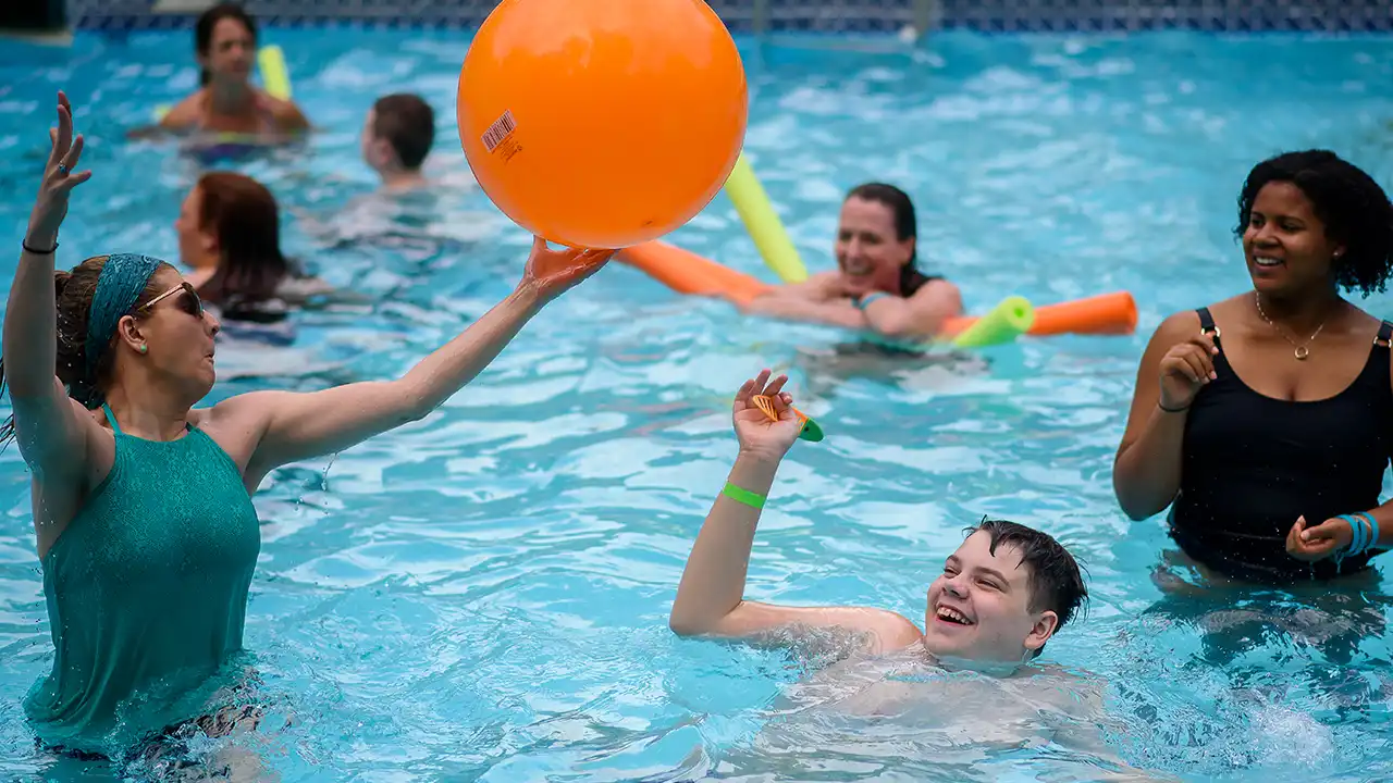 Young teens swimming in an outdoor pool at summer camp